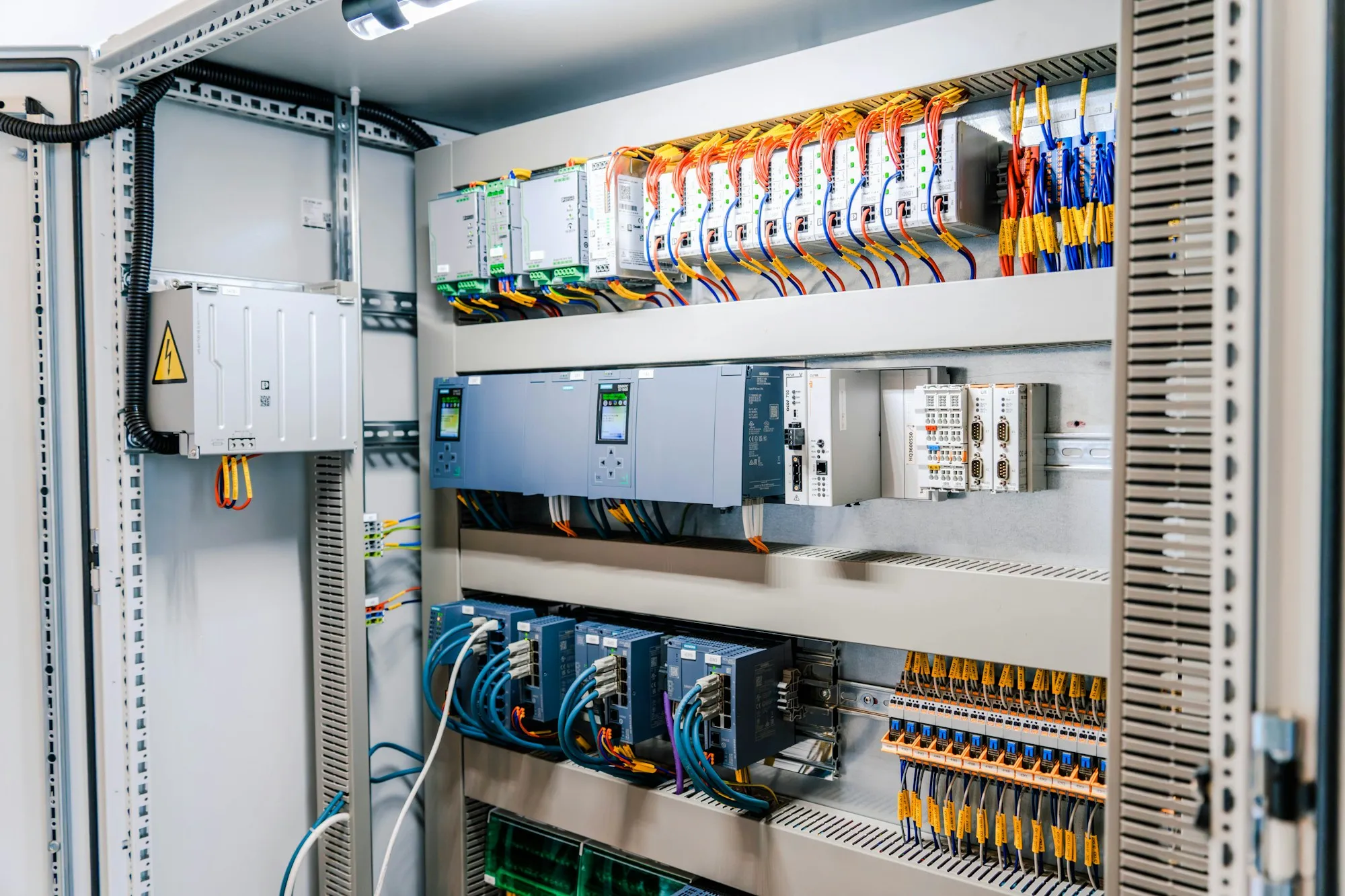 An open industrial control panel with wiring and modules