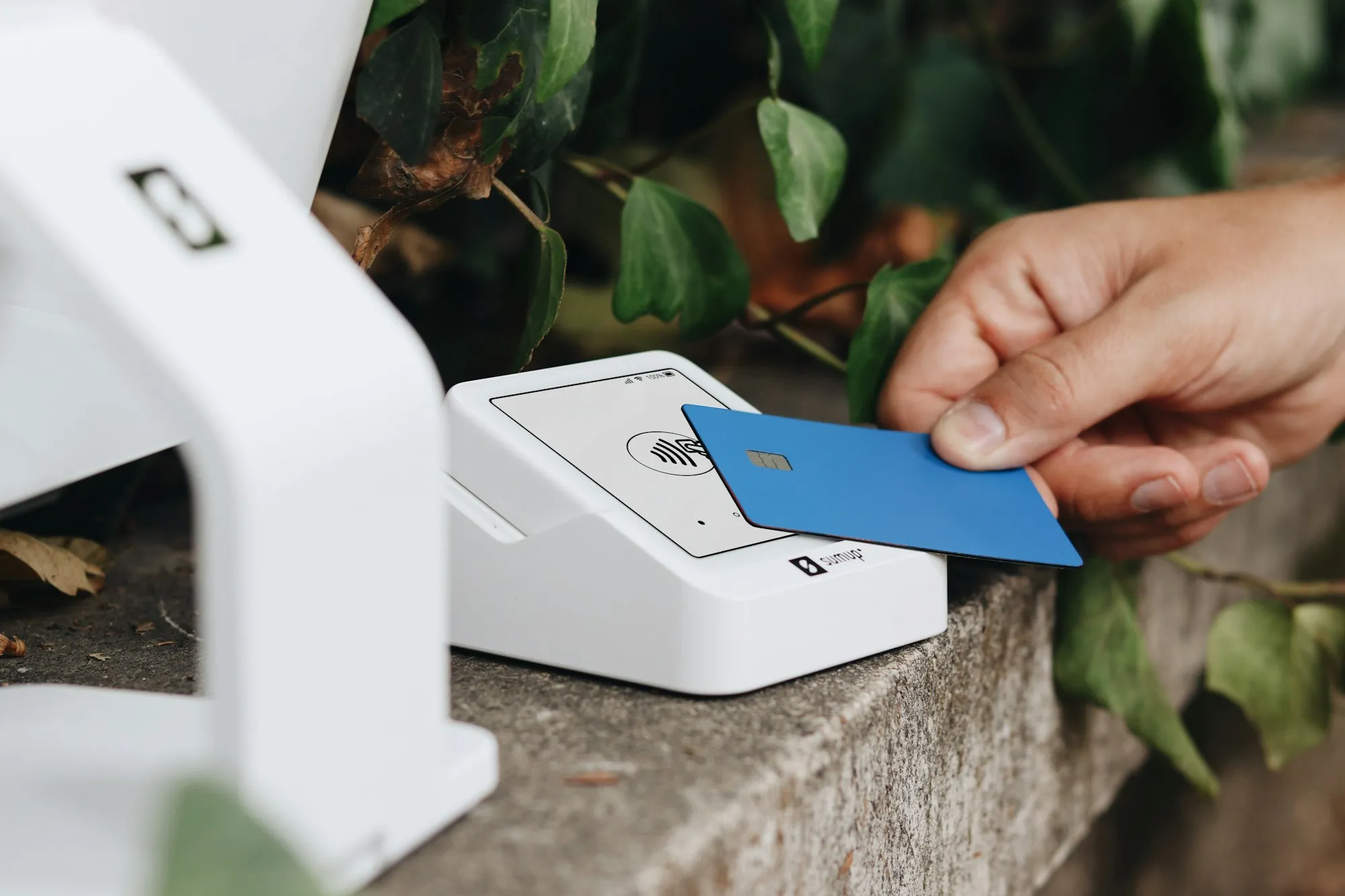 A customer tapping a card on a payment terminal