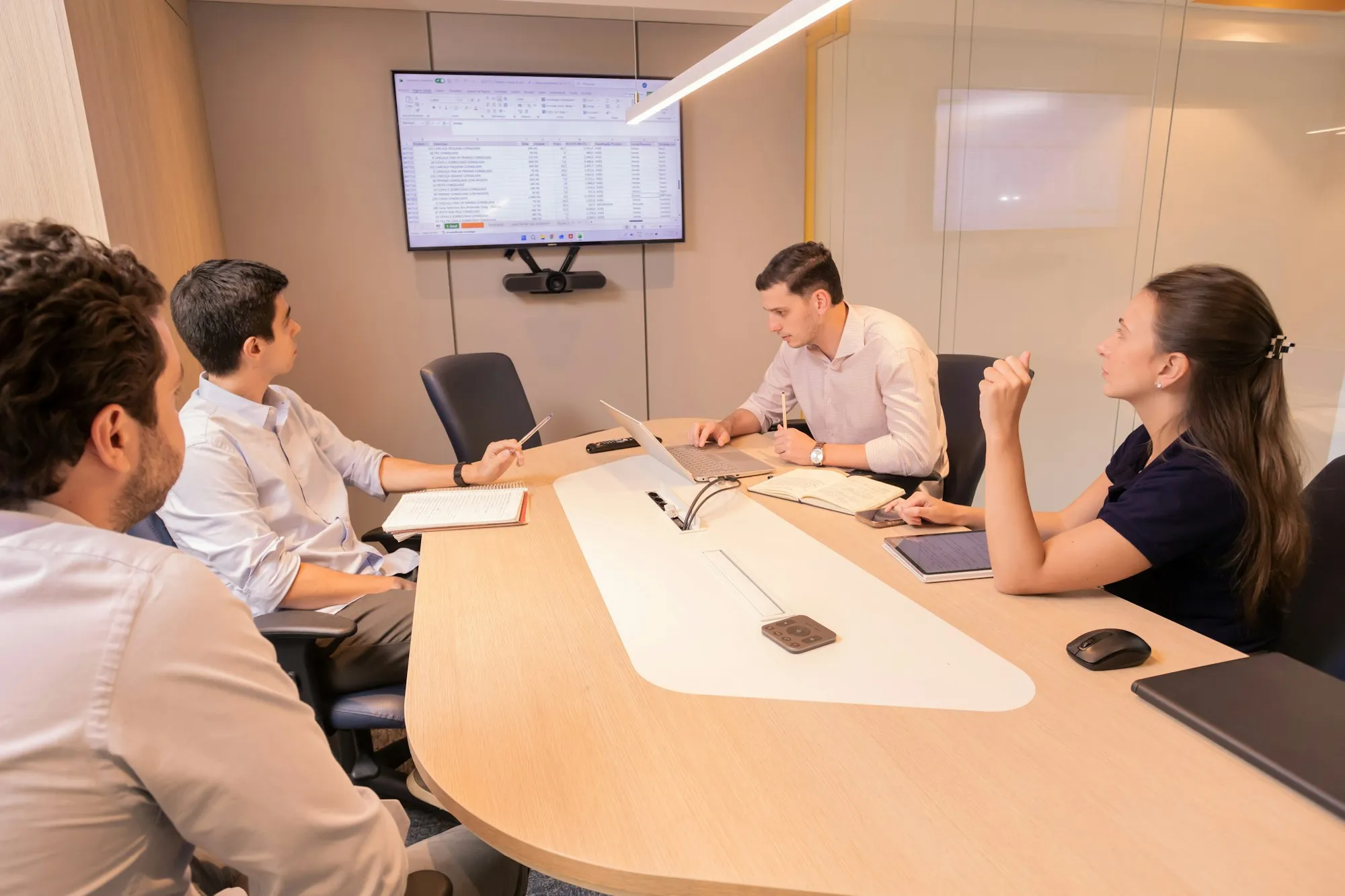A team reviewing figures on laptops in a modern meeting room