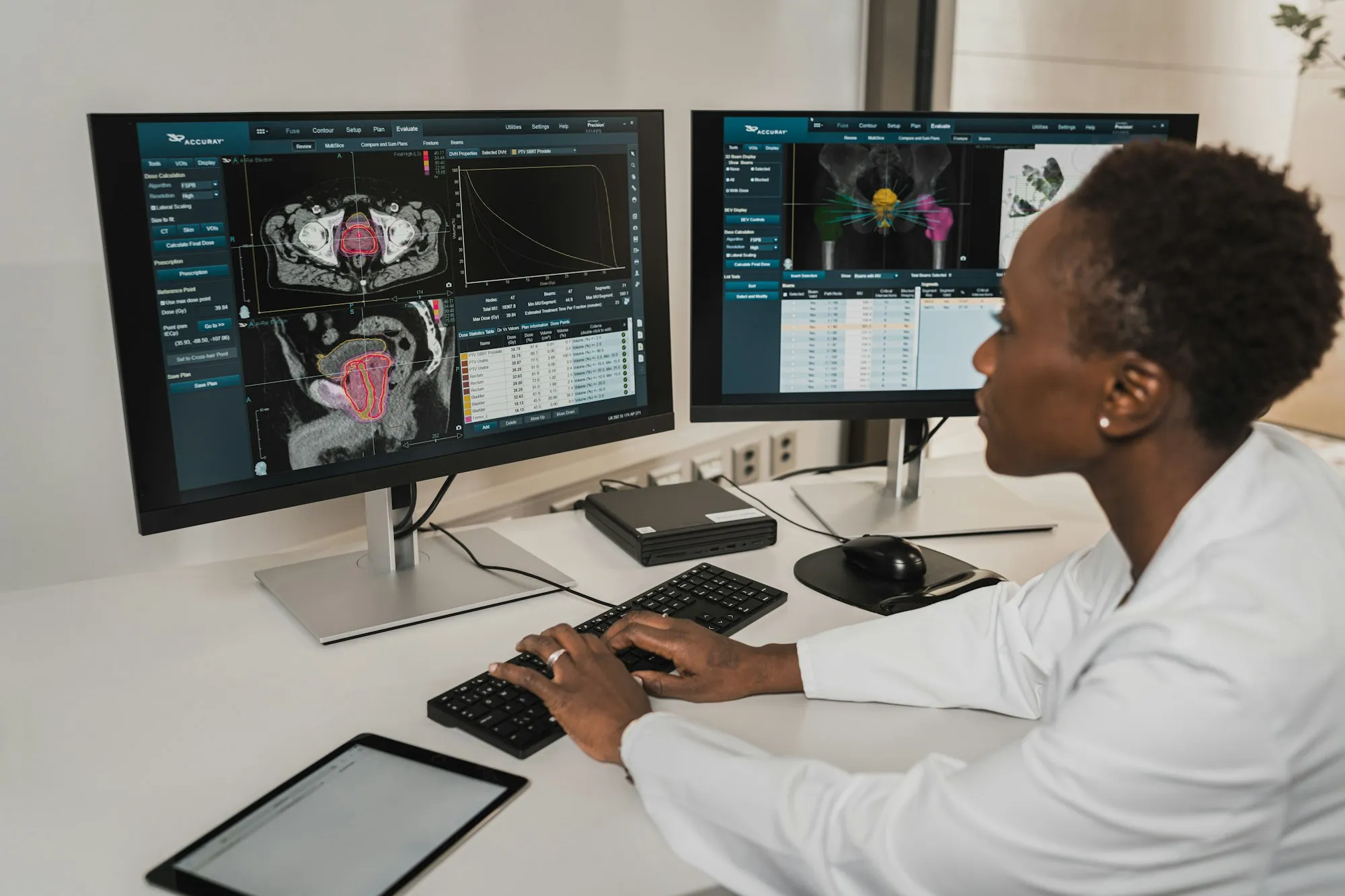A clinician working at two medical monitors